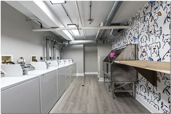 a workspace with white countertops and a wooden table with a pink flower on it